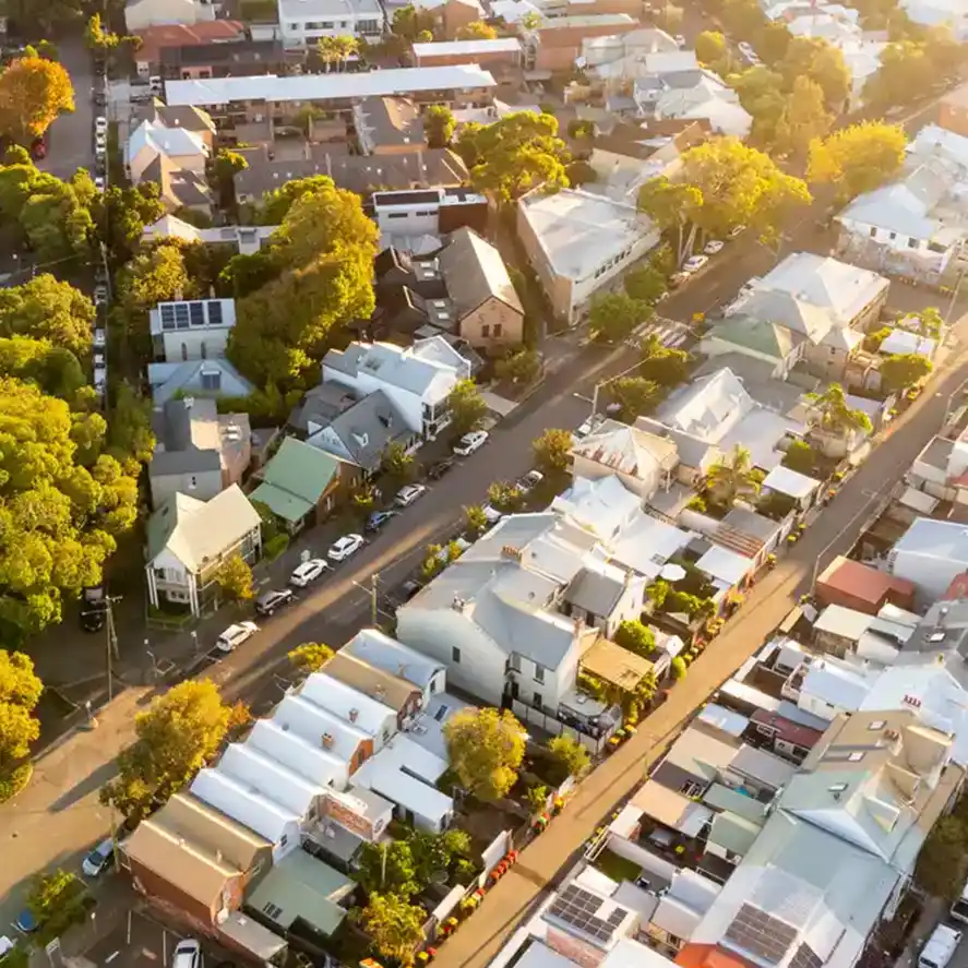 Drone shot of suburb in australia, the sunlight from sunrise streaming from top right corner.